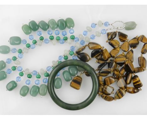 A green hard stone beaded necklace, together with a tiger eye beaded necklace and a jade bangle.