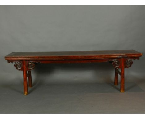 A Chinese hardwood bench having a moulded top, raised on chamfered scroll carved legs united by plain stretchers. H.55cm W.19
