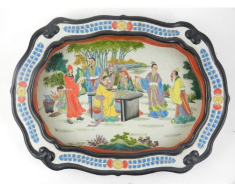 A modern Chinese porcelain basin dish of cartouche form, polychrome decorated in enamels with figures playing chequers amongs