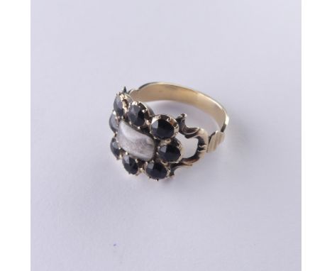 An early 19thC Mourning Ring, with central hairset box and glass surrounded by eight facetted circular black pastes, all moun