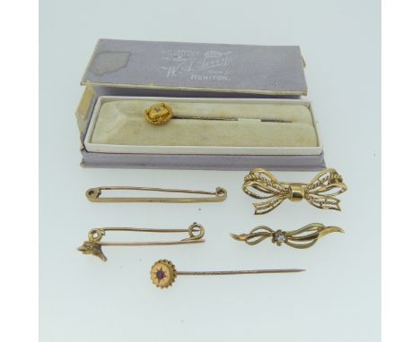 A 9ct yellow gold Bow Brooch, 3.5cm long, together with a 9ct gold bar brooch with fox mask at one end, 4cm long, two stick p