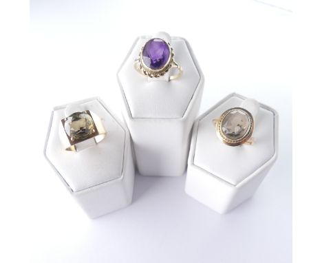A 9ct gold smoky quartz Ring, with ropetwist border, Size N, together with an amethyst ring, Size O and a citrine ring, Size 