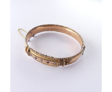 A late Victorian 9ct gold hinged Bangle, the front set with five ruby and diamond points, with ropetwist border, hallmarked C