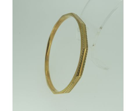 A 9ct gold Bangle, dodecagon with engraved edges, 7.3cm internal diameter, 14.1g. 