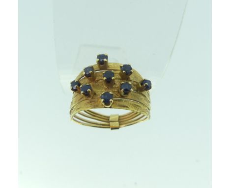 An 18ct yellow gold multi strand Ring, the front claw set with nine small sapphires, Size M, approx. total weight 3.1g. 