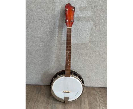 A Musima four string tenor banjo with figured sunburst back 