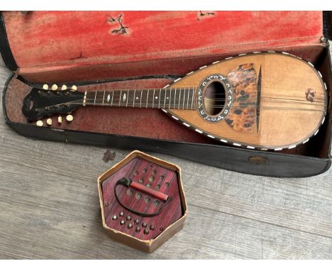 An early 20th Century round-back mandolin for restoration, cased, together with a German concertina, boxed (2)