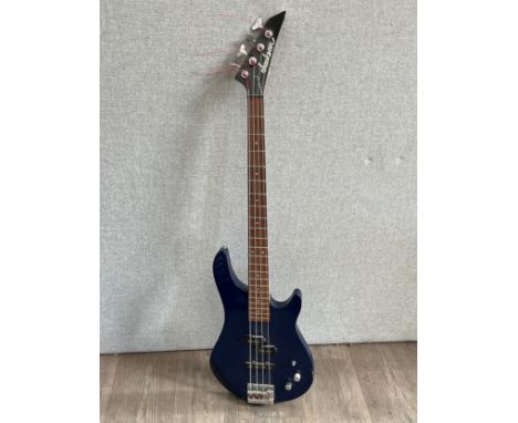 A Jackson electric bass guitar, navy blue body, some damage
