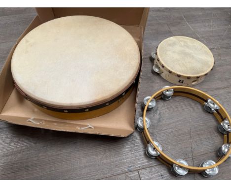 A boxed bodhran drum and beater, two tambourines