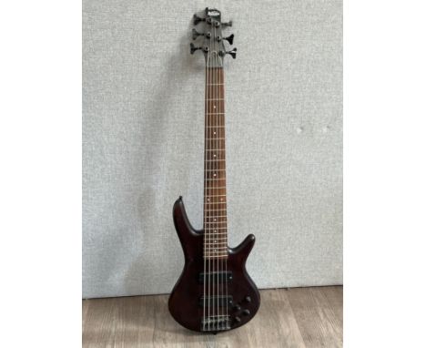 An Ibanez Gio Soundgear six string electric bass guitar with dark natural body 