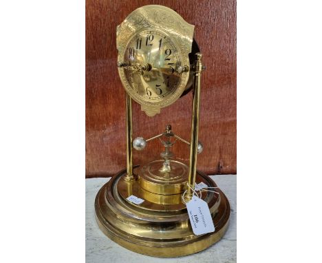 Brass perpetual motion mantle clock, lacking its dome. 28cm high approx. (B.P. 21% + VAT)  Incomplete - scale plate and suspe