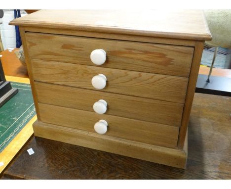 Small tabletop pine four drawer coin/specimen cabinet with ceramic knob handles.  41x50x33cm approx.  (B.P. 21% + VAT) 