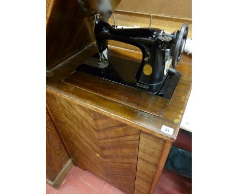 Singer manual sewing machine in cabinet