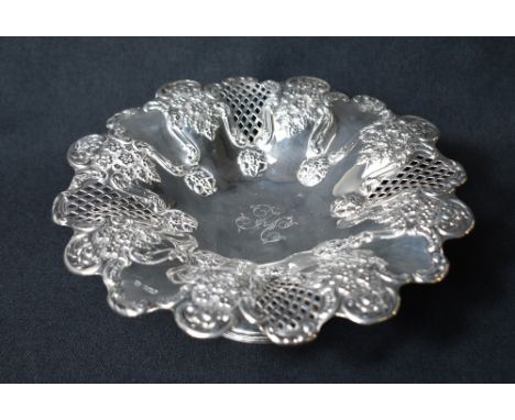 An Edwardian silver pedestal fruit bowl, having a lobed rim with embossed floral decoration and diaper panels, with a central