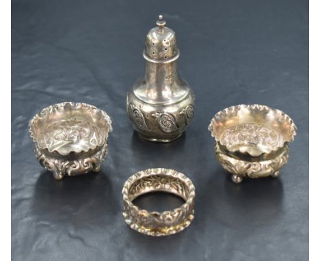 A pair of Edwardian silver salts, of circular form having crimped rim and embossed scroll decoration to the body, raised on t