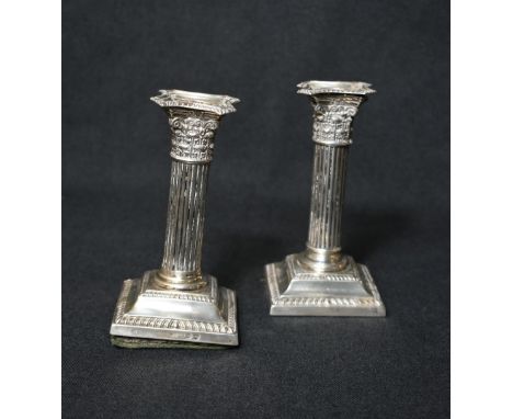 A pair of Victorian silver Corinthian column candlesticks, having concave square detachable sconces with gadrooned trim, embo