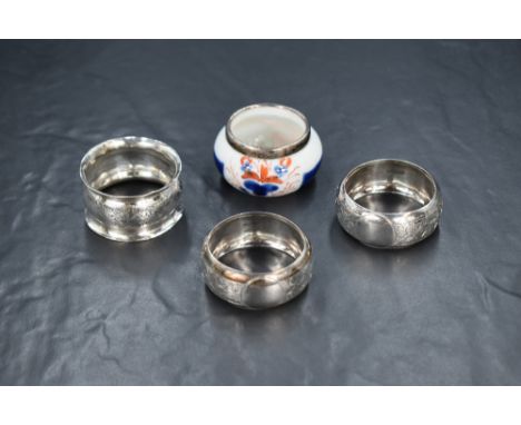 A pair of late Edwardian silver napkin rings, having engraved floral decoration with vacant circular cartouches, marks for Bi