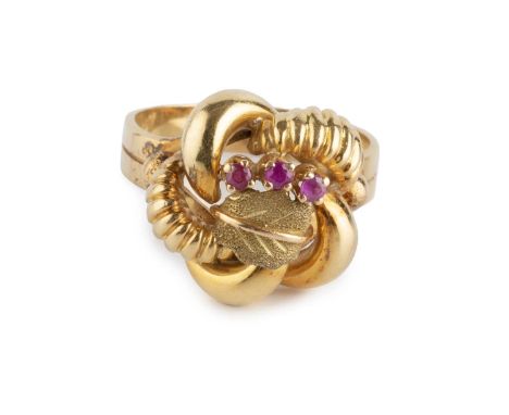 A stone set dress ring, the twisted panel with foliate and bead accents, highlighted with a trio of circular-cut red stones, 