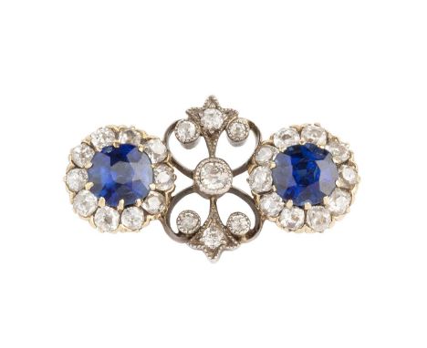 A diamond set panel brooch, designed as two old-cut diamond clusters, each centred with a cushion-shaped blue stone, spaced b