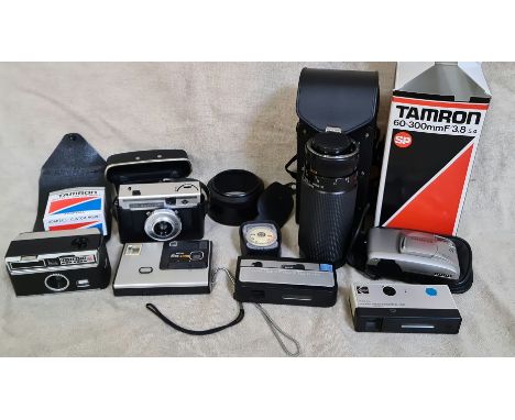 A box of assorted cameras and accessories including a Tamron 60-300mm F/3.8-5.4 macro lens, Agfa and Olympus etc.  