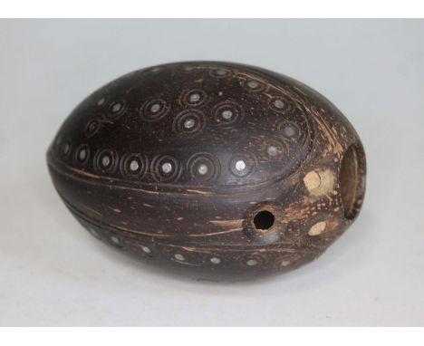 A small carved coconut nut "bugbear" with mother of pearl inlay, length 12.5cm.  
