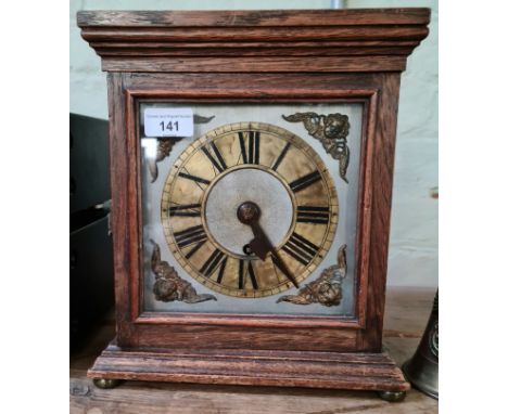 An oak cased mantle clock having brass and silvered dial with Roman Numerals and four pillar brass single fusee movement, hei