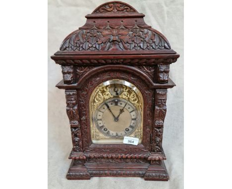 A carved oak cased mantle clock.