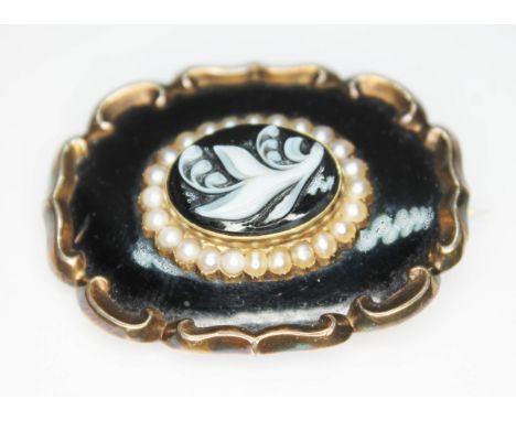 A 19th century mourning brooch, the central oval agate cameo surrounded by a row of pearls, enamel ground and scroll border, 