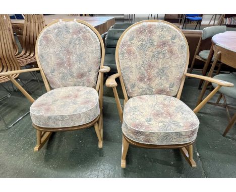 A pair of Ercol light wood rocking chairs with stick backs and loose cushions