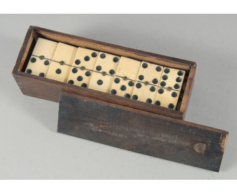 A BOX OF BONE DOMINOES.