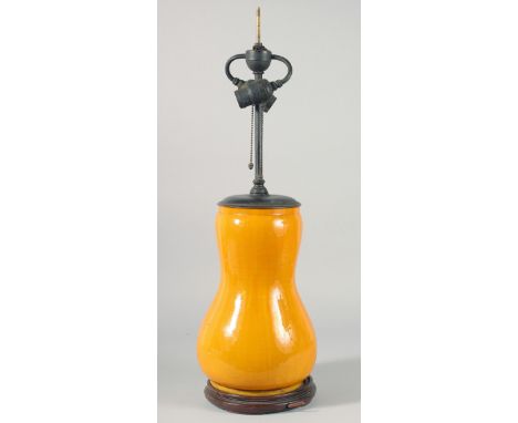 A CHINESE YELLOW PORCELAIN LAMP VASE on a wooden base. 13ins high.