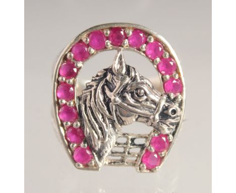 A SILVER AND FAUX RUBY HORSESHOE RING.