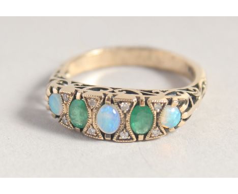 A 9CT GOLD OPAL, DIAMOND AND EMERALD RING.