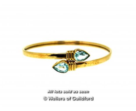 Blue topaz bangle, pear shaped blue topaz rubover set to each end in a 9ct yellow gold crossover design, gross weight 8.9 gra