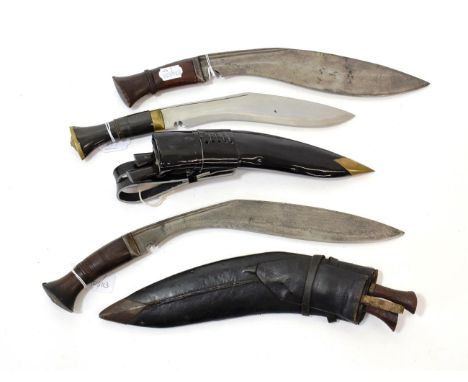 Two Nepalese Kukri, each with broad curved steel blade with double fullered back edge, steel bolster and wood grip, one with 