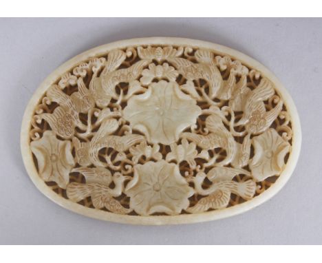 A CHINESE OVAL JADE-LIKE PLAQUE, pierced with birds and lotus, 4.5in x 3.1in at widest points.