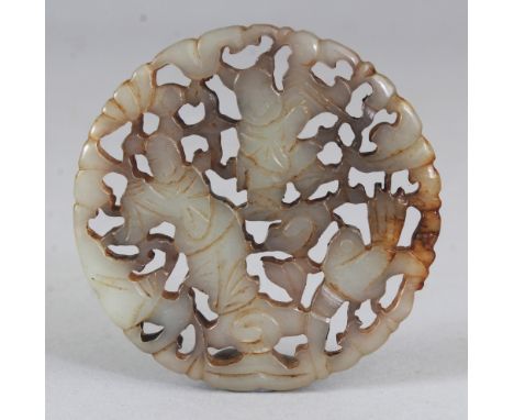 A CHINESE CIRCULAR PIERCED CELADON JADE PENDANT, decorated with a bird in flight above foliage, the stone with some russet co
