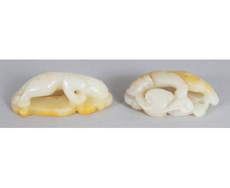 A GOOD PAIR OF CHINESE WHITE JADE CHILONG & PHOENIX CARVINGS, the stone with pale russet inclusions, 2.7in & 2.5in long.