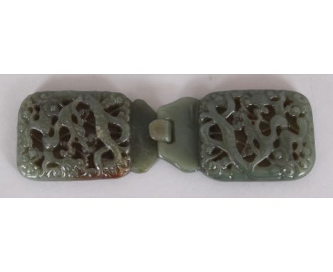 A CHINESE GREEN JADE-LIKE PIERCED DRAGON BELT HOOK, in two sections, 5.75in wide when linked.