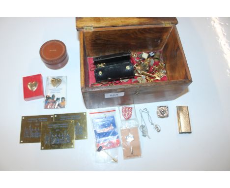 A wooden box and contents including cigarette lighter, cuff-links, badges etc. 