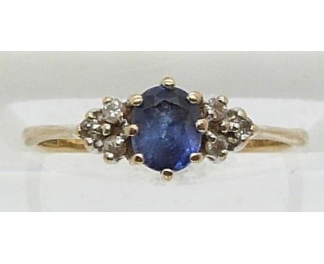 A 9ct gold ring set with an oval sapphire and six diamonds (size J)