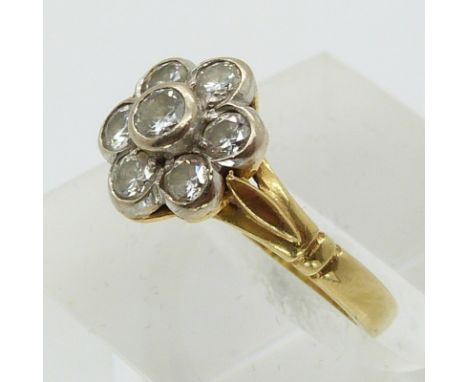 An 18ct gold ring set with seven round cut diamonds in a cluster (size G/H)