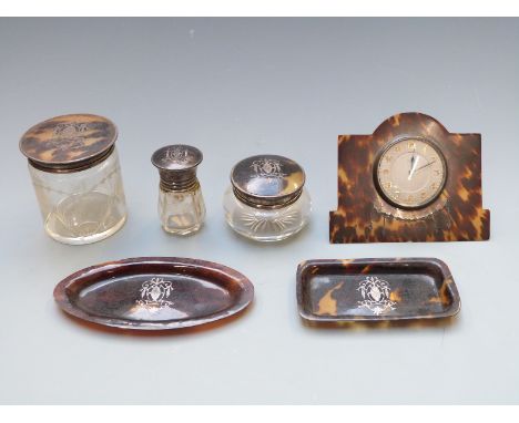 Six tortoiseshell pique work dressing table items comprising clock, three hallmarked silver lidded items, two being London 19