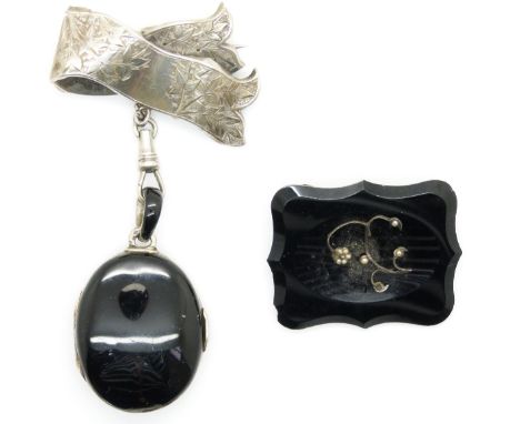 A silver brooch with foliate decoration, a Victorian locket set with black enamel and seed pearls and an onyx brooch set with