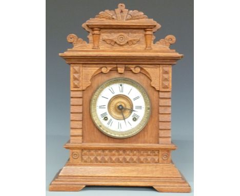 Ansonia oak table/mantel clock in carved case with Roman dial and beetle and poker hands, striking on a gong, 45cm tall