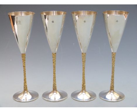 Stuart Devlin set of four modern hallmarked silver champagne flutes with retro bark effect stems, London 1978 maker Stuart De