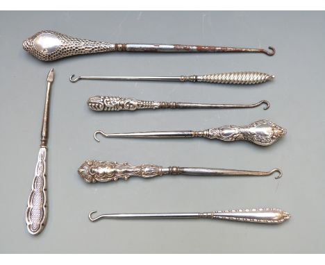 Seven various early 20th century hallmarked silver button hooks, length of longest 24cm