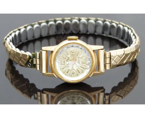 MuDu 18ct gold ladies wristwatch with gold hands and markers, multi-faceted bezel and 17 jewel movement, on expanding metal b