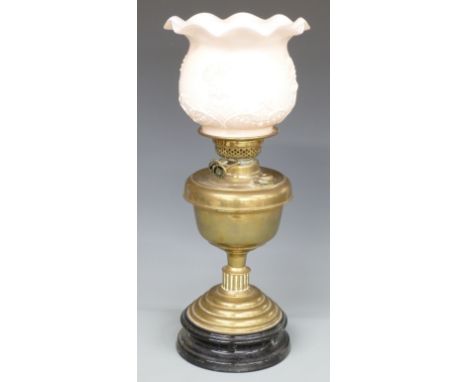 Brass oil lamp on black lacquered pottery base, the pale pink milk glass shade with embossed decoration