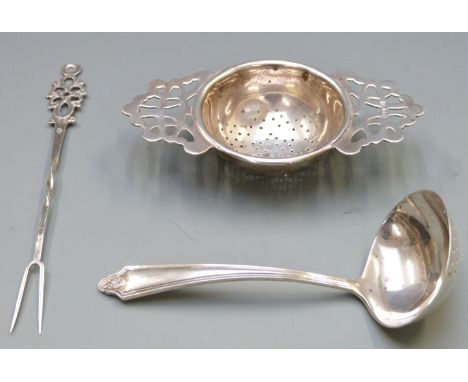 Hallmarked silver tea strainer, hallmarked silver sifter spoon and a continental white metal pickle fork, weight 67g